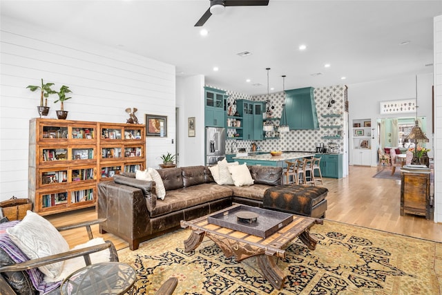 living area featuring recessed lighting, light wood-style flooring, and a ceiling fan