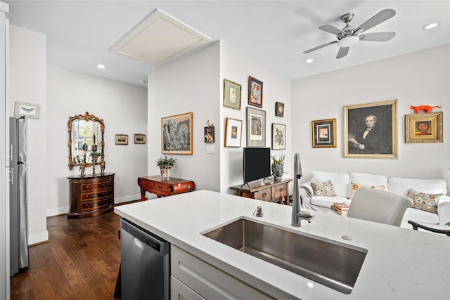 kitchen with a sink, light stone counters, recessed lighting, stainless steel appliances, and dark wood-style flooring