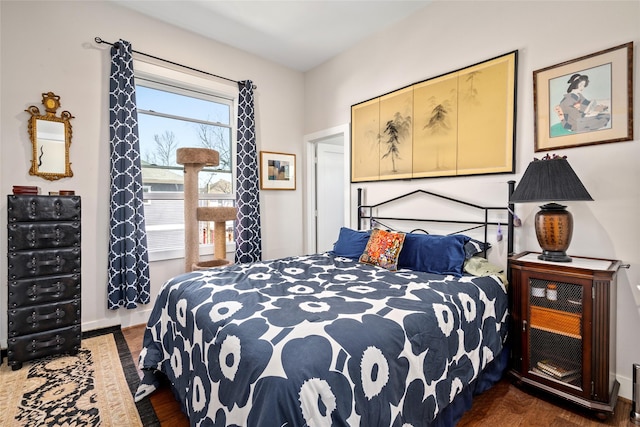 bedroom with baseboards and dark wood-style flooring