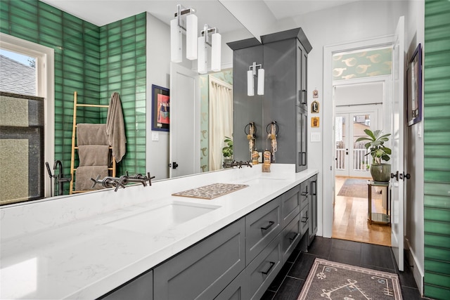 full bath featuring double vanity, wood finish floors, and a sink