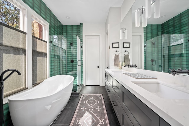 full bath featuring double vanity, a stall shower, and a sink