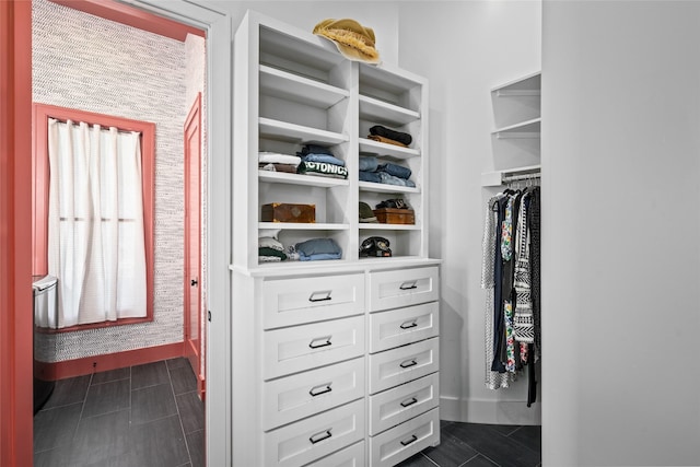 spacious closet with dark tile patterned floors