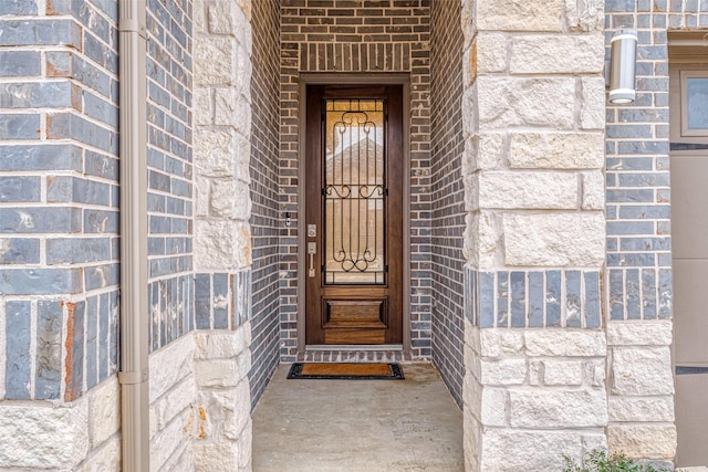 doorway to property featuring brick siding