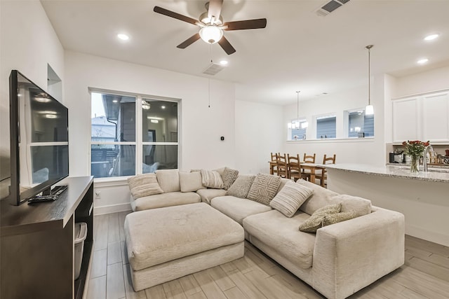 living room with ceiling fan, a wealth of natural light, and light hardwood / wood-style floors