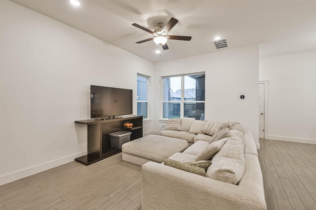 living room with light wood-type flooring and ceiling fan