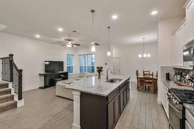 kitchen featuring decorative light fixtures, sink, white cabinetry, and stainless steel appliances