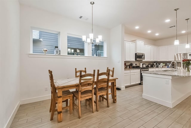 kitchen with white cabinets, stainless steel appliances, and decorative light fixtures