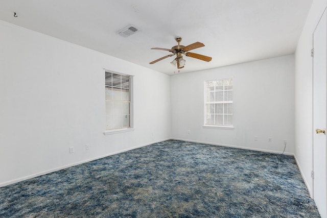 carpeted spare room featuring ceiling fan