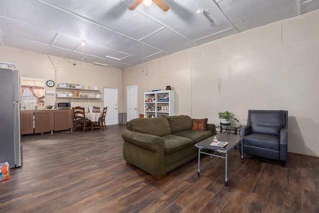 living room with ceiling fan and dark hardwood / wood-style flooring