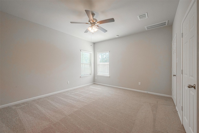 carpeted spare room with ceiling fan