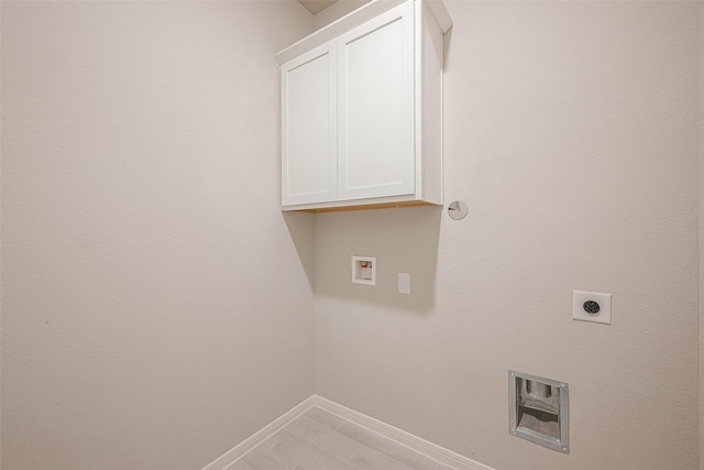 clothes washing area with hookup for a washing machine, cabinets, and hookup for an electric dryer