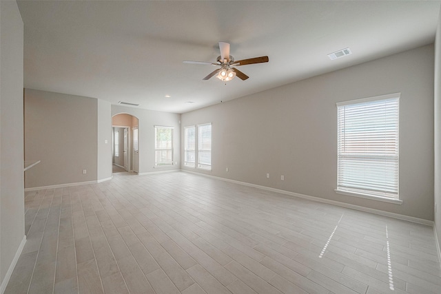 empty room with ceiling fan and light hardwood / wood-style flooring