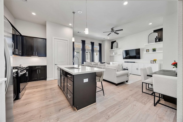 108 Knightsbridge Park Ln, Houston, TX 77018 - kitchen featuring appliances with stainless steel finishes, hanging light fixtures, a kitchen bar, sink, and a kitchen island with sink
