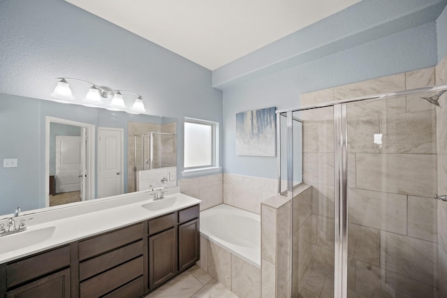 full bath featuring a garden tub, a shower stall, and a sink