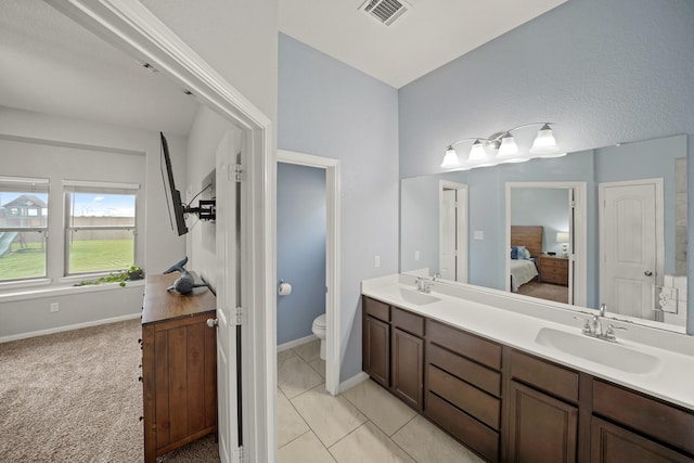 full bathroom with toilet, ensuite bath, visible vents, and a sink