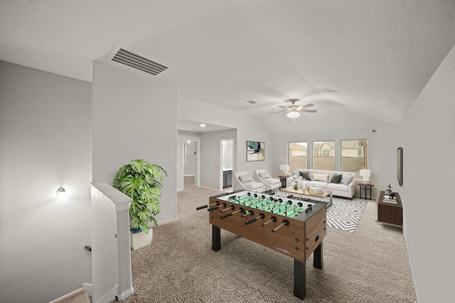 recreation room featuring lofted ceiling, a ceiling fan, visible vents, and light colored carpet