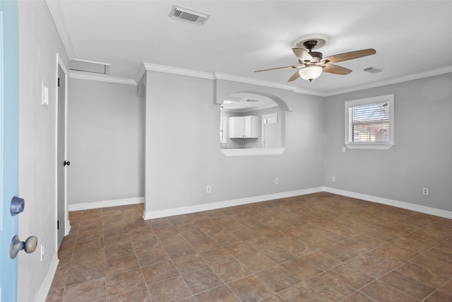 empty room featuring visible vents, crown molding, and baseboards