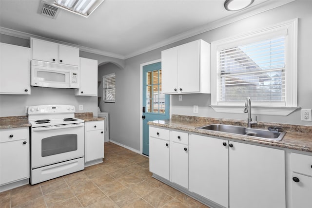 kitchen with visible vents, white appliances, white cabinetry, and a sink