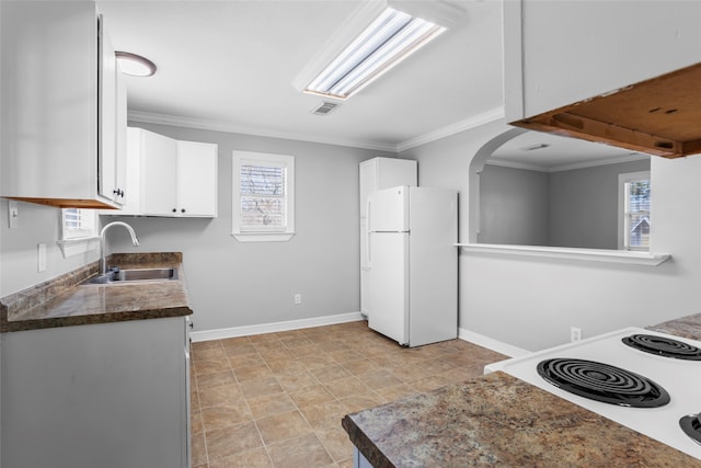 kitchen with visible vents, freestanding refrigerator, electric stove, white cabinets, and a sink