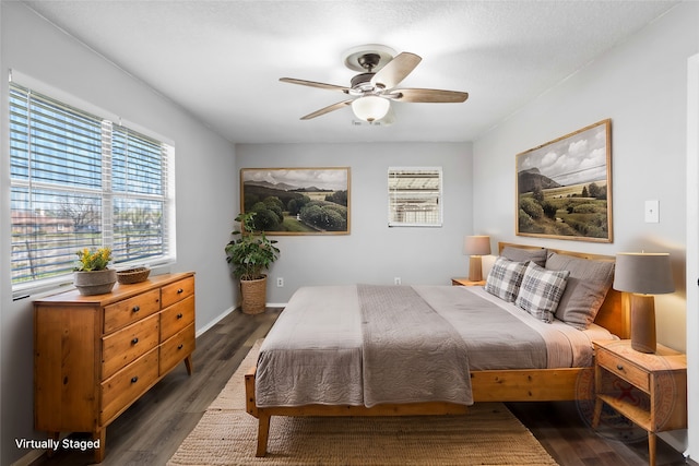 bedroom with baseboards, dark wood-type flooring, and ceiling fan