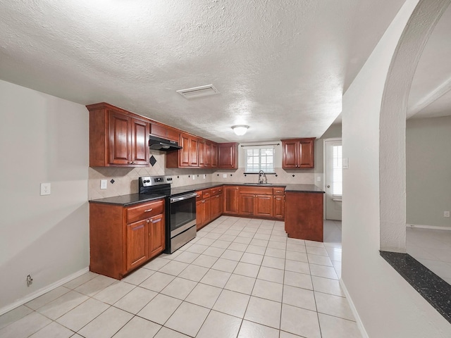 kitchen with a textured ceiling, light tile patterned flooring, backsplash, sink, and stainless steel electric stove