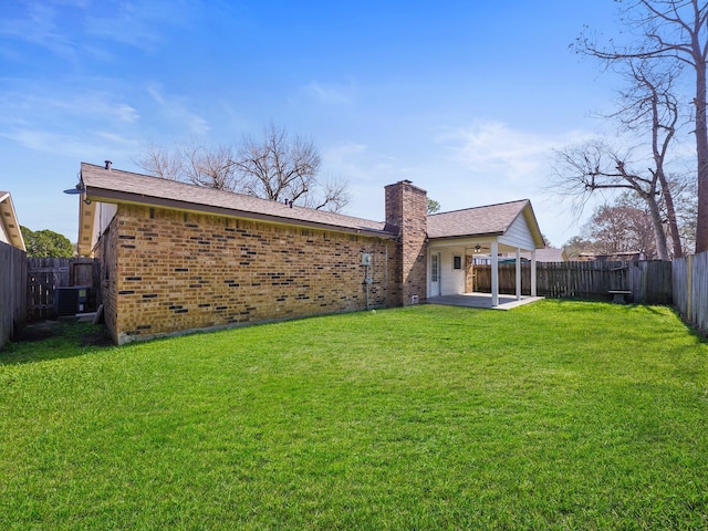 back of house with a patio area, a yard, and central AC