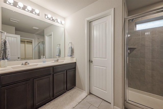 bathroom featuring tile patterned flooring, vanity, and a shower with shower door