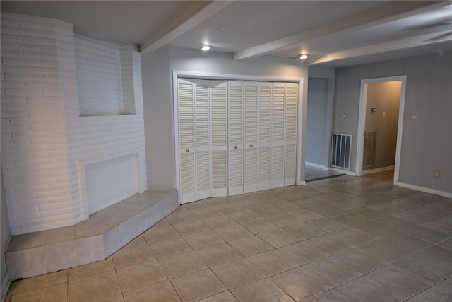 basement with a fireplace and light tile patterned flooring