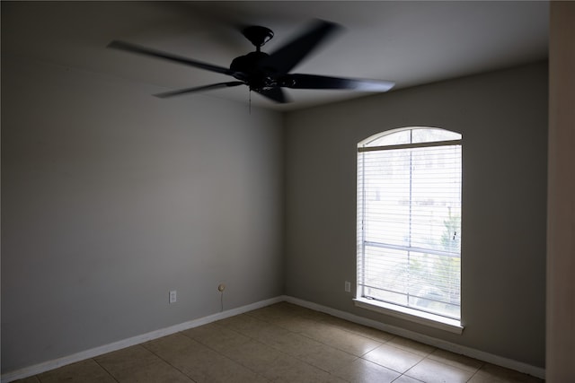 unfurnished room featuring ceiling fan, plenty of natural light, and light tile patterned floors