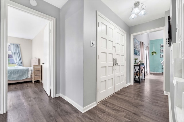 hall with dark wood-type flooring and baseboards