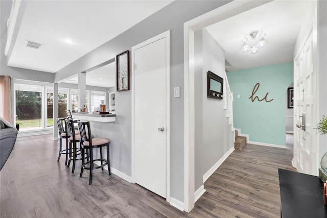 interior space featuring stairway, visible vents, baseboards, and wood finished floors