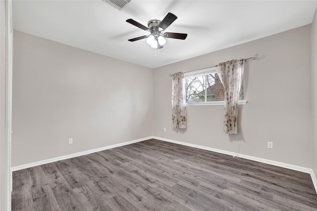 empty room with visible vents, baseboards, ceiling fan, and wood finished floors