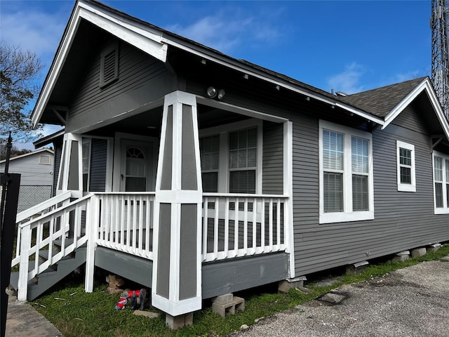 view of side of property with roof with shingles