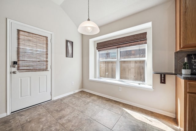 unfurnished dining area featuring light tile patterned floors and lofted ceiling