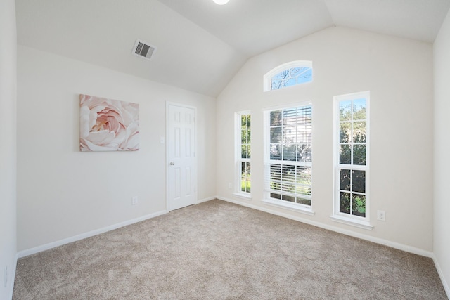 spare room with lofted ceiling and light colored carpet