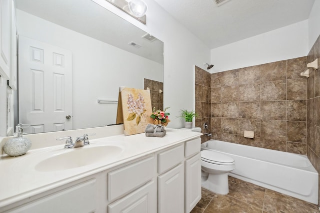 full bathroom featuring tiled shower / bath combo, toilet, and vanity