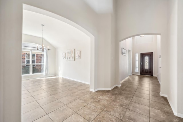 tiled entrance foyer with a high ceiling and an inviting chandelier