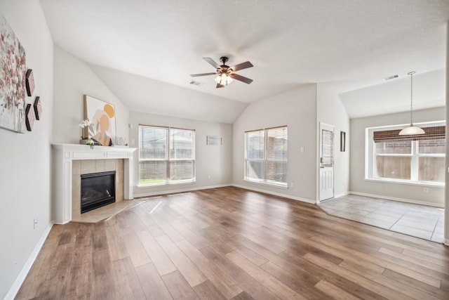 unfurnished living room with hardwood / wood-style flooring, ceiling fan, a fireplace, and lofted ceiling