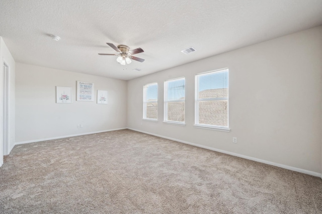 spare room featuring carpet, ceiling fan, and a textured ceiling