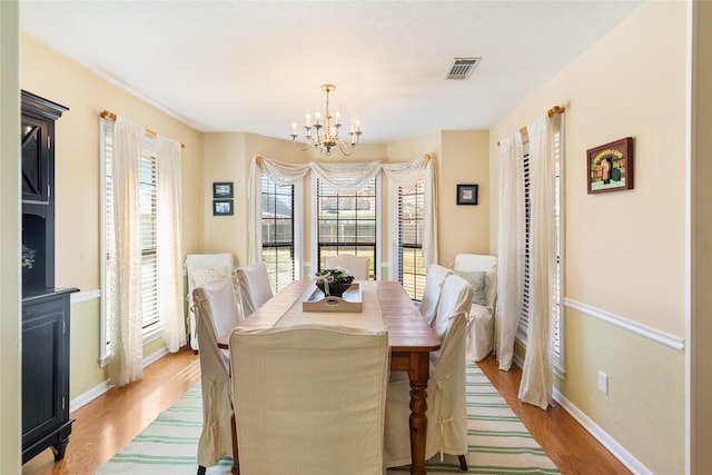 dining space featuring a notable chandelier and light hardwood / wood-style flooring