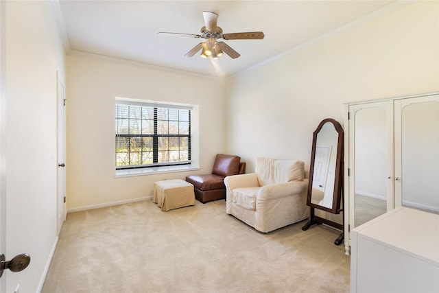 sitting room with ceiling fan, crown molding, and light carpet