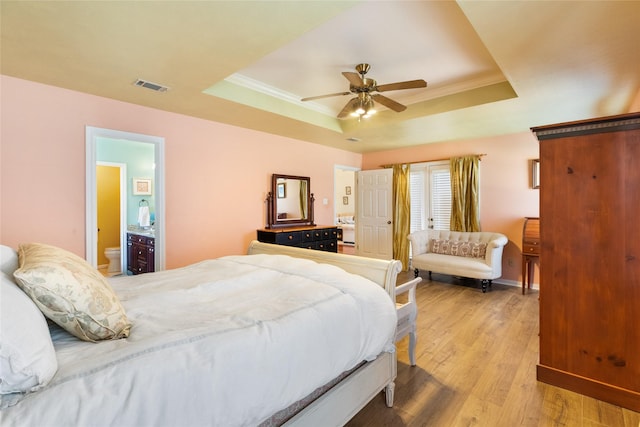 bedroom featuring ceiling fan, ornamental molding, light hardwood / wood-style floors, and a raised ceiling