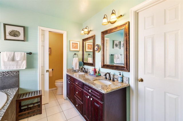 bathroom with toilet, vanity, and tile patterned flooring