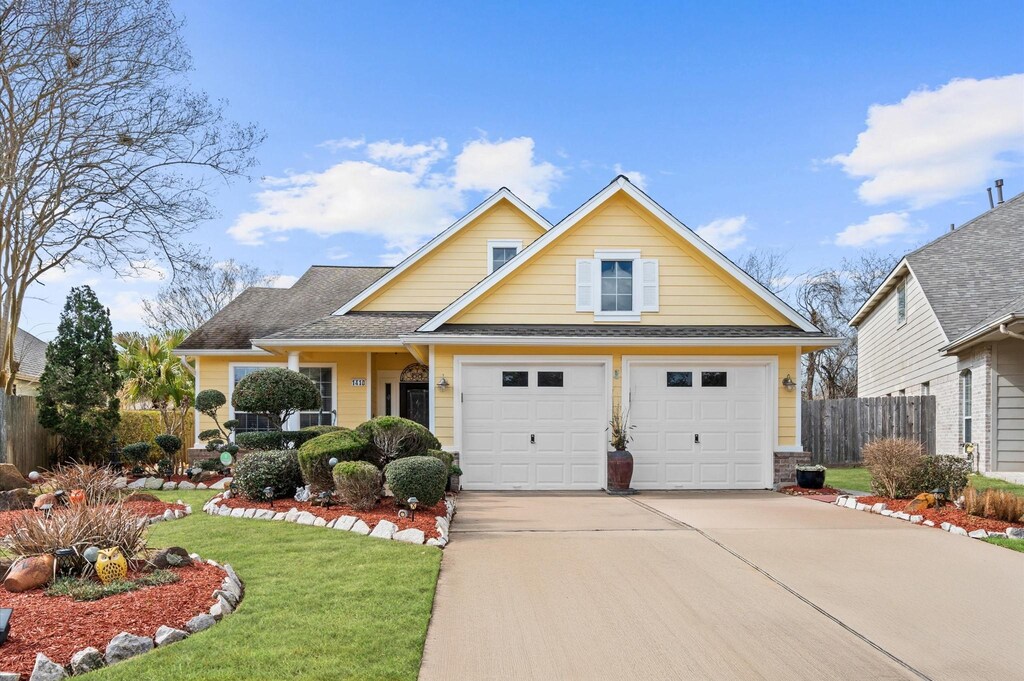 1410 Sunset Bay Ct, Pasadena, TX 77586 - traditional-style house with roof with shingles, fence, a garage, driveway, and a front lawn