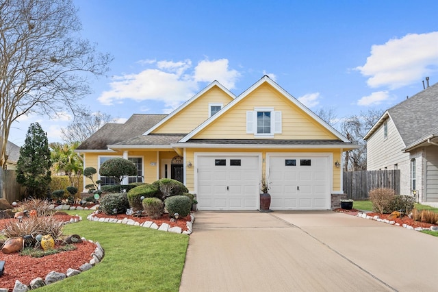 traditional-style house with roof with shingles, fence, a garage, driveway, and a front lawn