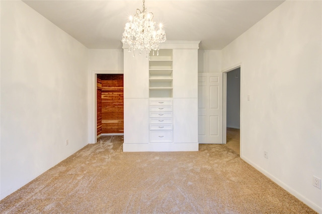 unfurnished bedroom with carpet, a closet, a spacious closet, and a notable chandelier