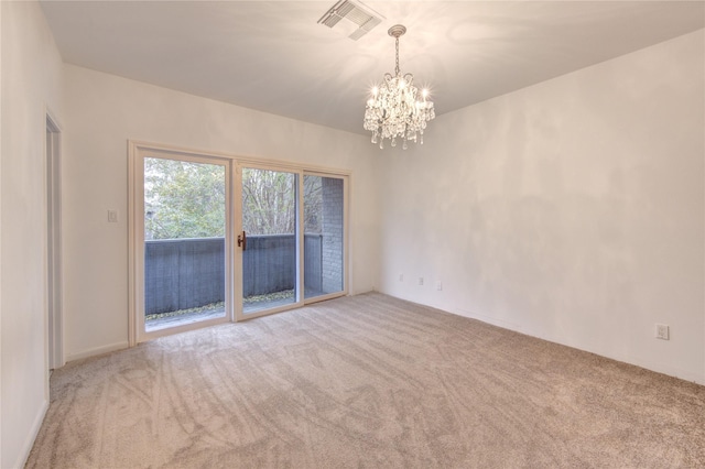 spare room with light colored carpet and an inviting chandelier