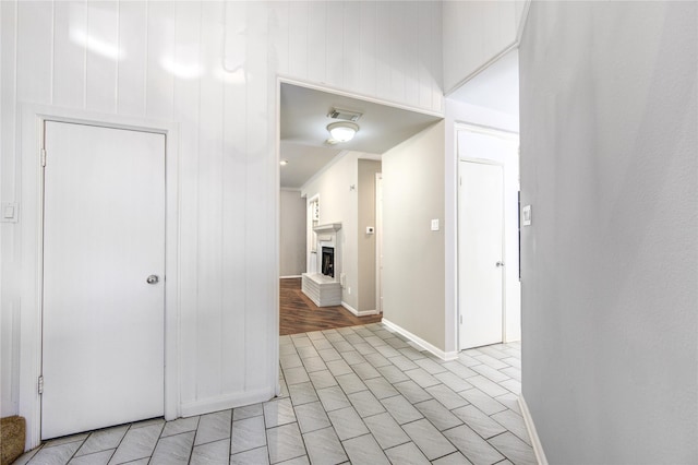 corridor featuring crown molding and light tile patterned flooring