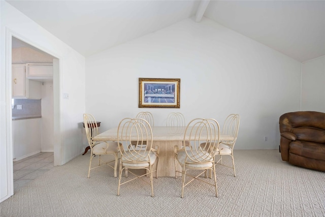 carpeted dining space with lofted ceiling with beams