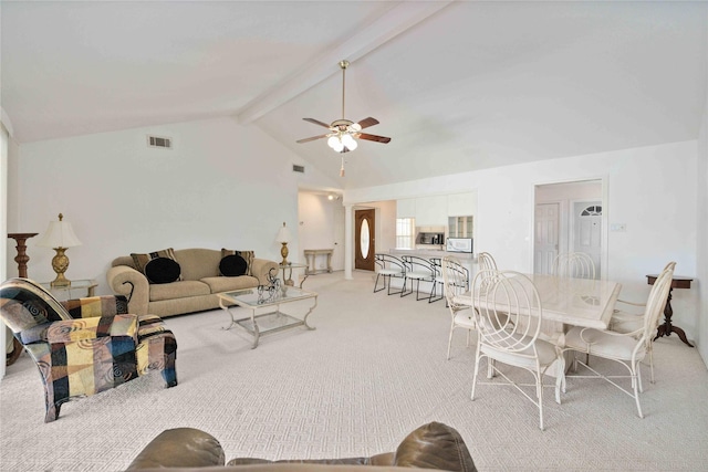 carpeted living room with vaulted ceiling with beams and ceiling fan